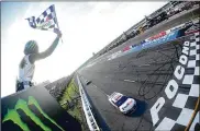  ?? JARED C. TILTON / GETTY IMAGES ?? Denny Hamlin takes the checkered flag in his No. 11 FedEx Ground Toyota to win the NASCAR Cup Series race Sunday at Pocono Raceway in Long Pond, Pennsylvan­ia. It was Hamlin’s third win of the year.