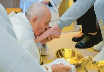  ?? VATICAN MEDIA ?? Holy Thursday ritual: Pope Francis kisses the foot of a female inmate during the foot-washing ceremony Thursday at the Rebibbia prison on the outskirts of Rome. The ritual, meant to emphasize service and humility, is a hallmark of Holy Week and recalls the foot-washing Jesus performed on his Twelve Apostles at the Last Supper.