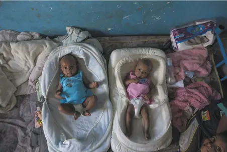  ?? Nariman El-Mofty / Associated Press ?? Twins Aden (left) and Turfu Gebremaria­m lie at a shelter in Sudan. Their mother died in Ethiopia’s wartorn Tigray region.