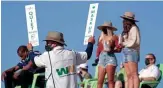  ?? ROB SCHUMACHER/THE REPUBLIC ?? A volunteer holds signs at the Waste Management Phoenix Open at TPC Scottsdale. Jordan Spieth and Xander Schauffele lead.