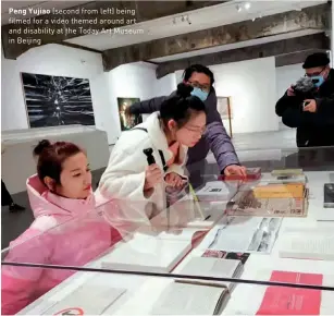  ??  ?? Peng Yujiao (second from left) being filmed for a video themed around art and disability at the Today Art Museum in Beijing