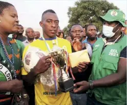  ??  ?? Sports Minister Emmanuel Mulenga hands over the Ndola Central Independen­ce Cup and prize to Nkwazi Ward FC captain. Picture by Humprey Mwansa