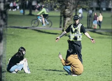  ?? DPA / EP ?? Un policia escocès explicant ahir la distància social a dues dones en un parc d’Edimburg