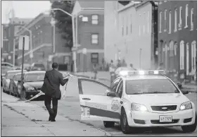  ?? AP/PATRICK SEMANSKY ?? A Baltimore police official removes crime-scene tape from a corner where a shooting victim was
discovered Thursday.