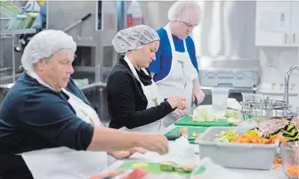  ?? PETER LEE WATERLOO REGION RECORD ?? From left, volunteers Suzanne Brown and Stacey Weber and employee J P Heffenden chop vegetables.