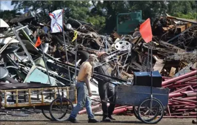  ??  ?? Brothers Richard Lichty and Steve Hoyland drop off a load of metal.