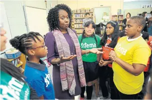  ?? DAN PEARCE METROLAND ?? A group of St. Martin de Porres Catholic School students ask MPP Mitzie Hunter about the provincial cuts to their music program. Sistema provides music programs for at-risk youth.