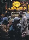  ??  ?? People in protective face masks shop in Istanbul at the start of Ramadan