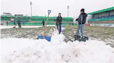  ?? FOTO: DPA ?? Tagsüber räumen Freiwillig­e Schnee im Lotter Stadion.
