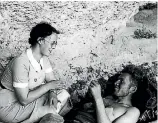  ??  ?? A nurse chats with an injured volunteer at Ebro Front Cave Field Hospital.