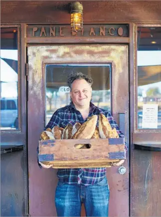  ?? David Loftus ?? PHOENIX pizza legend Chris Bianco of the renowned Pizzeria Bianco, here hauling loaves at his Pane Bianco restaurant, has a cookbook out — his first — as well as big plans for Los Angeles.