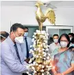  ??  ?? Dr. Mahendra Somathilak­a lights the lamp