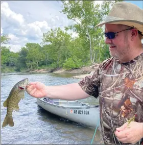  ?? (Arkansas Democrat-Gazette/Bryan Hendricks) ?? ABOVE Alan Thomas of Benton caught a bunch of smallmouth bass like this one Friday in a small section of the Caddo River near the Amity Access. BELOW LEFT Thomas ties on a lure with the aid of drugstore reading glasses. BELOW RIGHT Thomas loaded his kayak with everything he needed for a day of creek fishing.