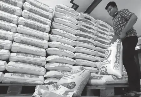  ?? HENG SINITH / AP ?? A vendor piles sacks of rice for sale in Phnom Penh, Cambodia. The country has announced that a two-month ban on the export of standard-grade white rice, imposed to ensure sufficient domestic supplies of staple foods during the coronaviru­s crisis, will be lifted on Wednesday.