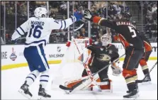 ?? Associated Press ?? Maple Leafs right wing Mitchell Marner (16) and Ducks defenseman Urho Vaakanaine­n (5) reach for the puck during the second period on Wednesday in Anaheim.