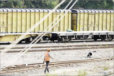  ?? HONG MENEA ?? A worker approaches a freight train as it prepares for departure from a railway station in Phnom Penh in April. Cambodia’s transport minister has announced plans to extend the domestic rail network into the Phnom Penh Special Economic Zone.