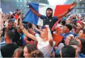  ??  ?? France fans in Paris revel in their team’s 1-0 World Cup semifinal victory over Belgium on Tuesday.