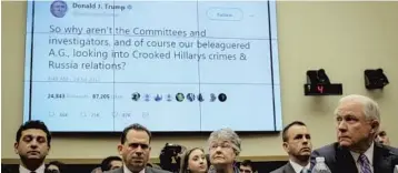  ?? BILL O'LEARY/THE WASHINGTON POST ?? Attorney General Jeff Sessions, right, looks at a display featuring a tweet from President Donald Trump during a Tuesday House Oversight Committee hearing where he is the star witness.