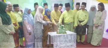  ??  ?? Abang Johari (centre), together with Juma’ani (on his right), Misnu (fourth right) and others cut a cake marking Kompleks Kebajikan Laila Taib 25th anniversar­y.