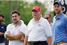  ?? SETH WENIG/ASSOCIATED PRESS ?? From left, Yasir Al-Rumayyan, a governor of Saudi Arabia’s Public Investment Fund, which is financing the LIV Golf series, former President Donald Trump and his son, Eric Trump, watch play Thursday in the pro-am round of the Bedminster Invitation­al LIV Golf in Bedminster, N.J.
