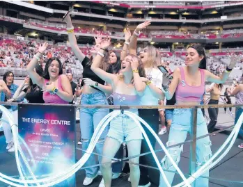  ?? RICK SCUTERI/INVISION PHOTOS ?? Concertgoe­rs dance, at left, and other fans ride stationary bikes, top right, during Coldplay’s “Music of the Spheres” world tour on May 12 at State Farm Stadium in Glendale, Arizona. At lower right, bassist Guy Berryman, left, and lead singer Chris Martin of Coldplay perform on the same night at the venue.