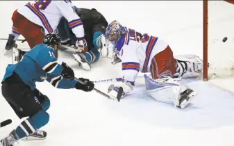  ?? Tony Avelar / Associated Press ?? Sharks center Joe Thornton fires the go-ahead goal past Rangers goalie Henrik Lundqvist.