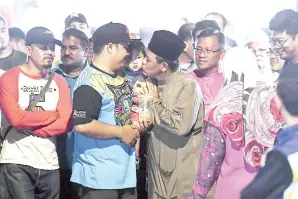  ?? -Gambar Bernama ?? AMINUDDIN (tengah) beramah mesra dengan sebahagian pengunjung di Bazar Malam, Senawang ketika hadir pada pemeriksaa­n khas terhadap tapak-tapak Bazar Malam sepanjang bulan Ramadan di Dataran Senawang.