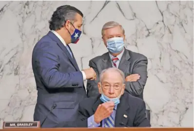  ?? KEVIN DIETSCH/ POOL VIA AP ?? Judiciary Committee Chairman Sen. Lindsey Graham, R-S.C., stands with Sen. Ted Cruz, R-Texas, left, behind Sen. Chuck Grassley, R-Iowa, during the confirmati­on hearing for Supreme Court nominee Amy Coney Barrett on Thursday on Capitol Hill in Washington.