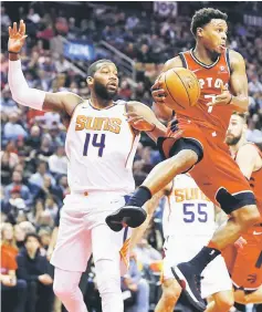  ??  ?? Toronto Raptors guard Kyle Lowry (right) goes to pass the ball as Phoenix Suns centre Greg Monroe (14) looks on during the first half at Air Canada Centre. — USA TODAY Sports