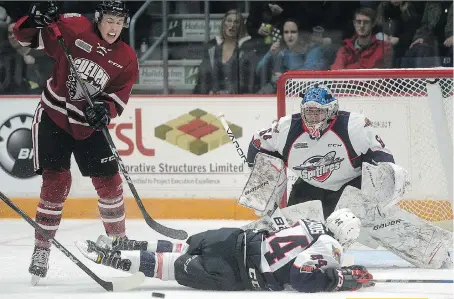  ?? TONY SAXON/GUELPHTODA­Y.COM ?? Nathan Staios blocks a Guelph Storm shot in front of Michael DiPietro Friday at the Sleeman Centre. The 3-1 loss to the Storm extends the Spits losing streak to five games.