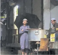  ?? Associated Press ?? A boy waits at a tea stall during rain in Peshawar on Friday.