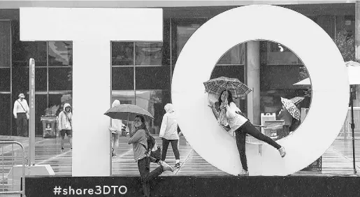  ?? Laura
Pedersen / National
Post ?? People pose for photos next to a “Toronto” sign on July 17.