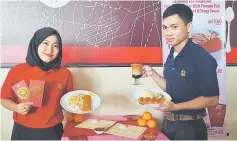  ??  ?? SugarBun staff showing the Fortune Fish Meal which features SugarBun’s fish fillet during a press conference held at iCom Square yesterday.