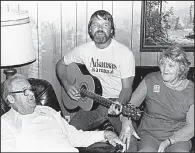  ?? Democrat- Gazette fi le photo ?? Glen Campbell visits his parents, Wes and Carrie Campbell, during a Christmast­ime trip to his hometown of Billstown near Delight in 1981.