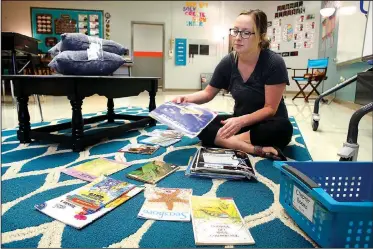  ?? NWA Democrat-Gazette/DAVID GOTTSCHALK ?? Laura Amos, a third-grade teacher at Asbell Elementary School, arranges books Thursday in her classroom in Fayettevil­le. Amos taught fourth grade at Grace Hill Elementary School in Rogers last year.