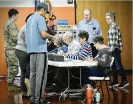  ?? MARSHALL GORBY / STAFF ?? Voters check in at Beavercree­k High School before voting Tuesday.