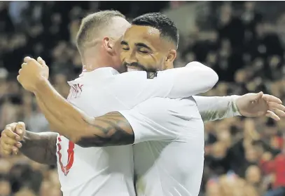  ?? Picture: AFP ?? THE OLD AND THE NEW. England’s Callum Wilson (right) hugs Wayne Rooney after the Bournemout­h striker netted their third goal against the US at Wembley on Thursday night.