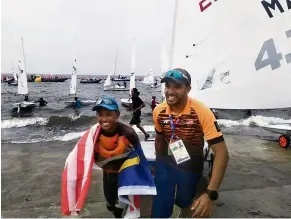  ??  ?? Hard at work: Sailors Khairulniz­am Mohd Afendy (right) and Fauzi Kaman Shah after a practice session at Ancol Beach yesterday.