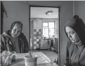  ?? ?? Iryna Abramova, left, prepares food April 22 with her neighbor Iryna Hres in remembranc­e of Hres’ mother. The elderly woman had died in early March during the occupation.