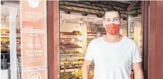  ?? FOTO: HIL ?? Tobias Bär im Eingang der Bäckerei Bär in der Montfortst­raße. Schilder weisen auf die Regeln im Geschäft hin.