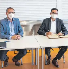  ?? FOTO: GEMEINDE WESTHAUSEN ?? Landrat Joachim Bläse (rechts) trägt sich im Rahmen seines Besuchs in das Goldene Buch der Gemeinde Westhausen ein. Links Bürgermeis­ter Markus Knoblauch.