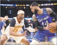  ?? Phelan M. Ebenhack / Associated Press ?? Orlando Magic guard D.J. Augustin, right, sets up in front of Atlanta Hawks forward Vince Carter during the second half on Friday.