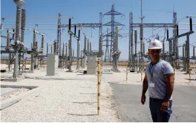  ??  ?? AN IEC employee stands at a power substation near Jenin.