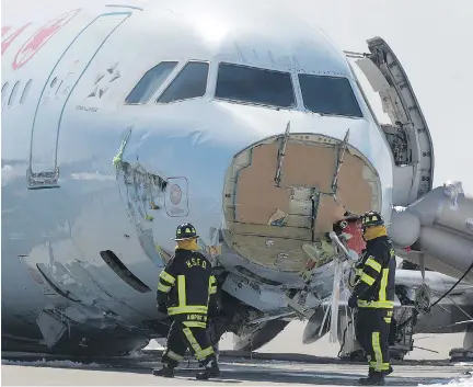  ??  ANDREW VAUGHAN/THE CANADIAN PRESS ?? Firefighte­rs work Monday at the Halifax airport where an Air Canada plane crashed during the weekend.