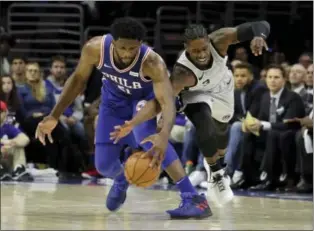  ?? MATT SLOCUM -AP ?? The Philadelph­ia 76ers’ Joel Embiid, left, and San Antonio Spurs’ Brandon Paul chase after a loose ball during the second half of an NBA basketball game, Wednesday, in Philadelph­ia. Philadelph­ia won 112-106.