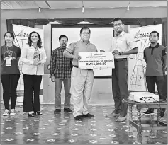  ??  ?? Malaysia Airports chief strategy officer Azli Mohamad (left) presents the contributi­on to a representa­tive of JKKK Rumah Mayung.