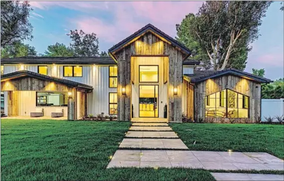  ?? Photog r aphs by Simon Berlyn Berlyn Photog r aphy ?? REMADE I NTO a modern farmhouse during Scott Disick’s stay, the Hidden Hills property has rustic wood panels on the outside.