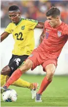  ?? ANDREW NELLES ?? Jamaica midfielder Devon Williams (22) and United States midfielder Christian Pulisic battle for the ball during the second half of Wednesday night’s CONCACAF Gold Cup semifinal game at Nissan Stadium. / TENNESSEAN.COM