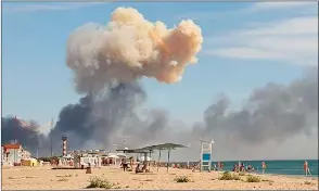  ?? The Associated Press ?? Rising smoke can be seen from the beach at Saky after explosions were heard from the direction of a Russian military airbase near Novofedori­vka, Crimea, Tuesday.