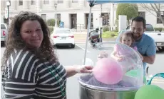  ?? (Caitlan Butler/ News-Times) ?? John and Raelyn Deichler watch as Mary Shoemaker, of Oh How Sweet Cotton Candy, makes a cotton candy treat for Raelyn at Shamrockin’ on the Square in downtown El Dorado Saturday afternoon.